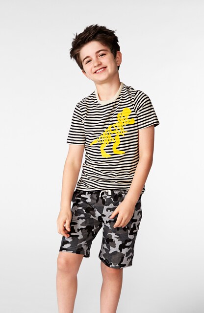 little boy in graphic tee and printed shorts