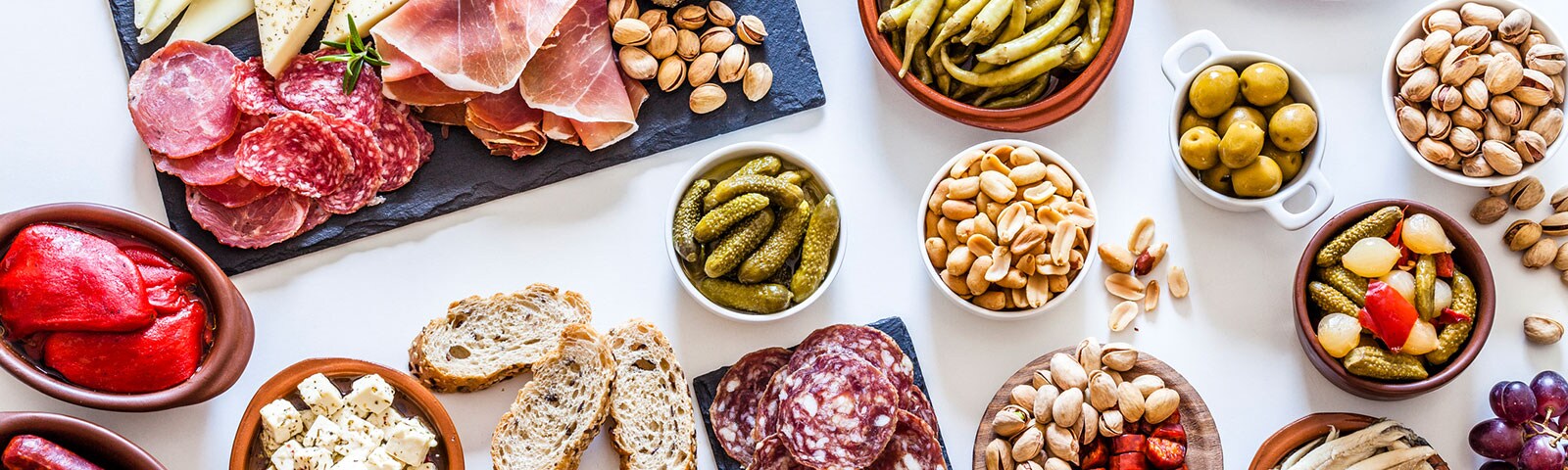 A variety of meats and cheeses, nuts and pickled vegetables to build a charcuterie board