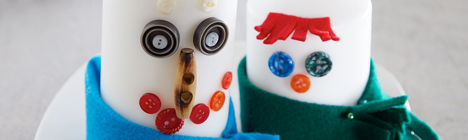 Planks of wood painted white and decorated to look like snowmen